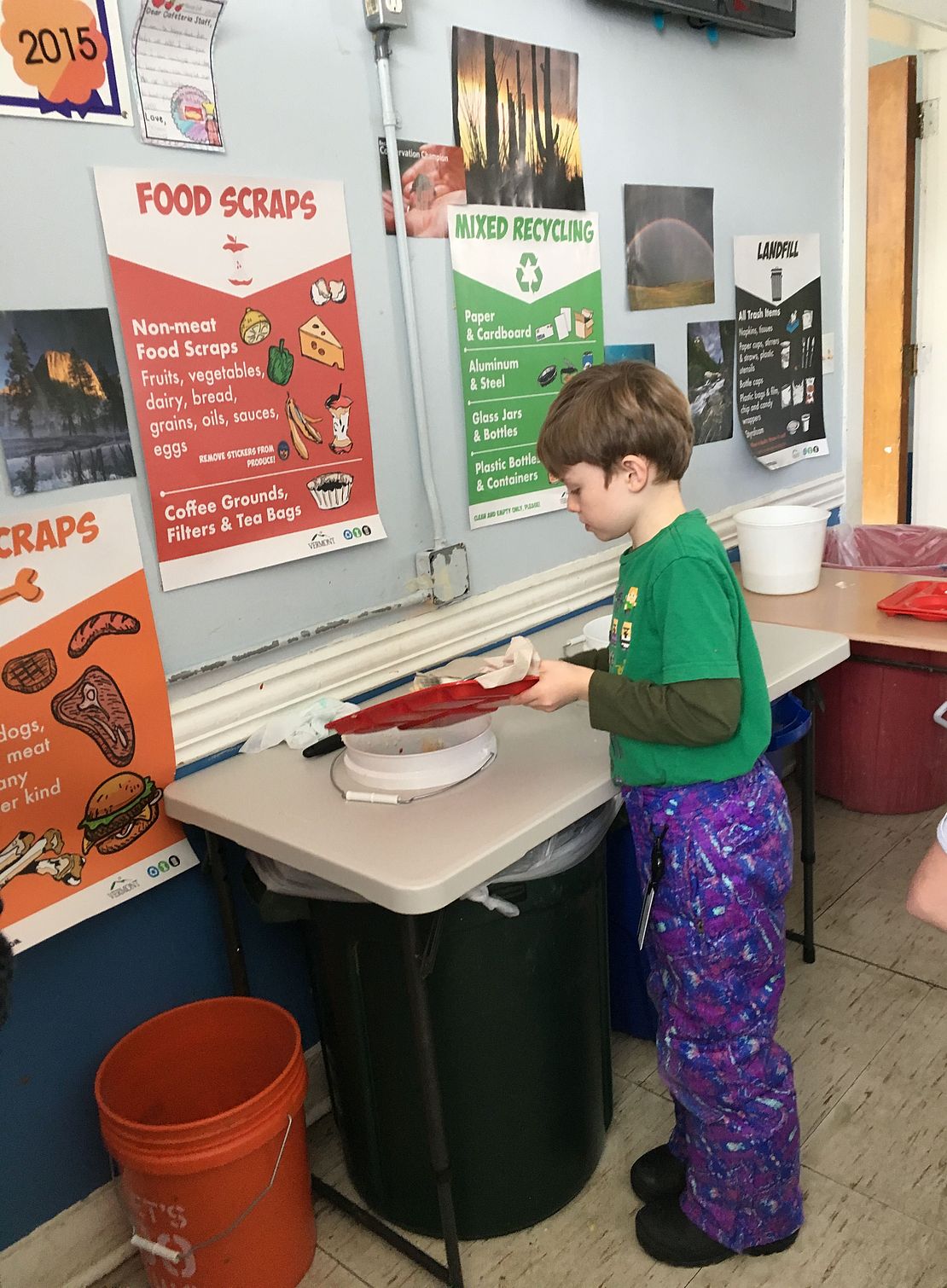 Student scraping their tray at a cafeteria sorting table