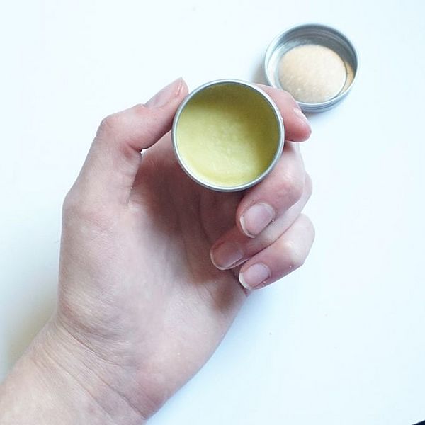 hand holding small container of lip balm