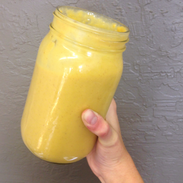 Hand holding mason jar filled with nacho cheese