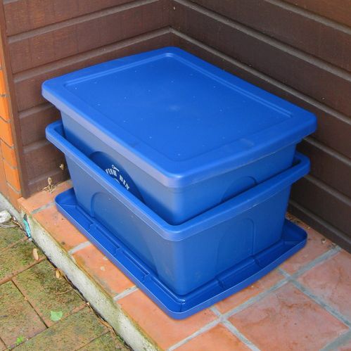 Two blue plastic bins stacked with one inside the other.