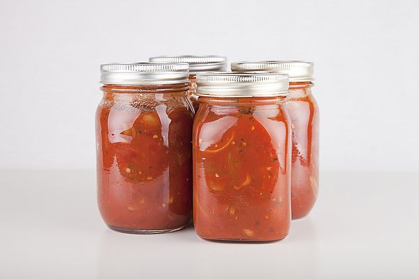 Four mason jars filled with tomato sauce