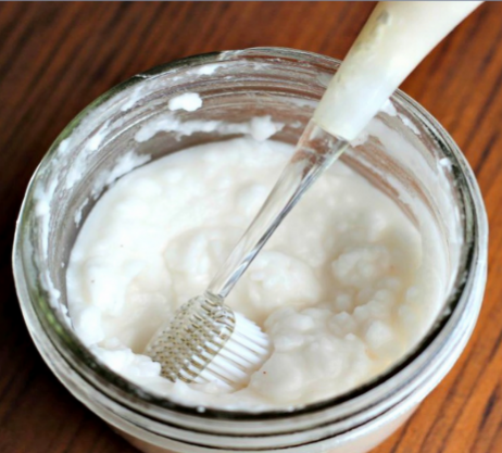 Jar of toothpaste with toothbrush in it