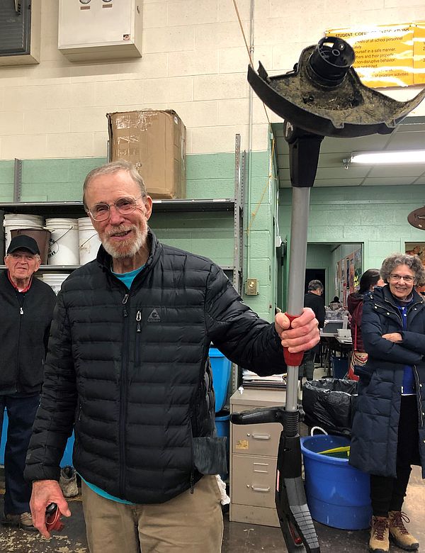 A Repair Fair participant holds up a repaired weed trimmer.