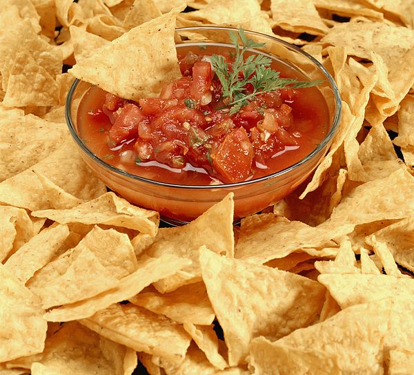 tortilla chips surrounding a bowl of salsa