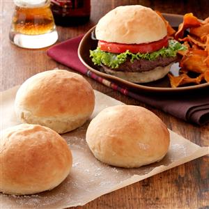 three dinner rolls and one hamburger on a plate with fries