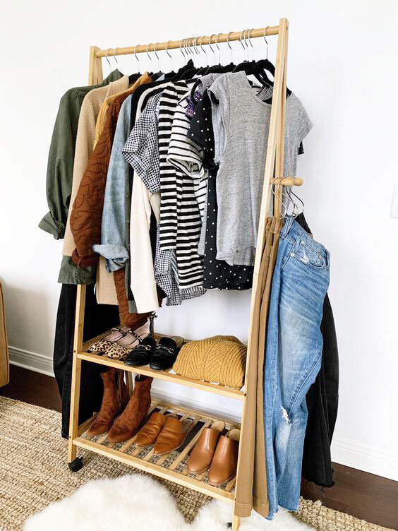 a simple clothing hanger holds minimal clothes, beneath which are five pairs of shoes